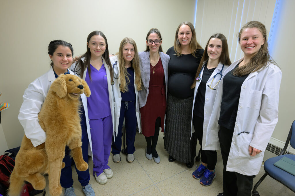 Sarah Calvin, third from right, and Stephanie Byrne, center, veterinarians who graduated from WSU’s College of Veterinary Medicine, pose for a photo with current DVM students and a simulated canine patient as they take part a Diagnostic Challenge session on Tuesday, Nov. 19, 2024, in Pullman.