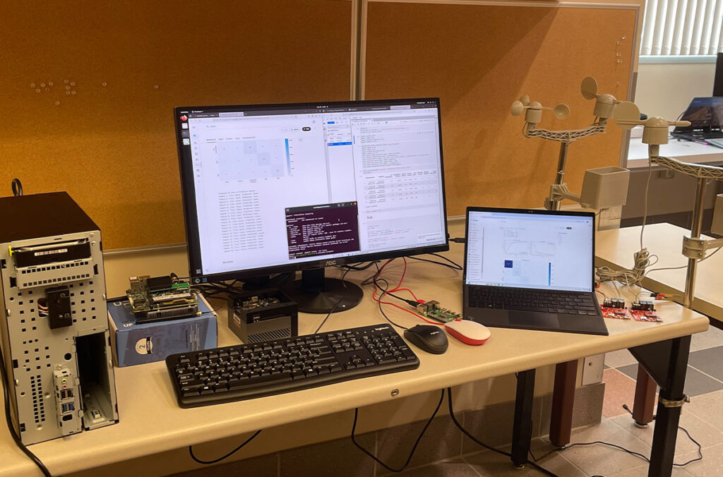 A laptop, desktop computer, and computerized sensors on a table.