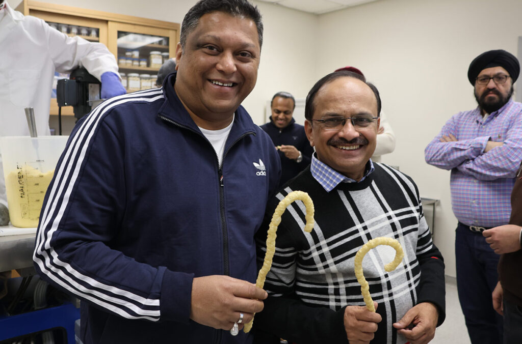 Swarup Solgaonkar, corporate chef for McDonald’s India, and Sudhir Tamne, senior vice president for quality and innovation for Burger King India, hold products made from pulse flours during a demonstration at the School of Food Science’s Food Processing Laboratory.