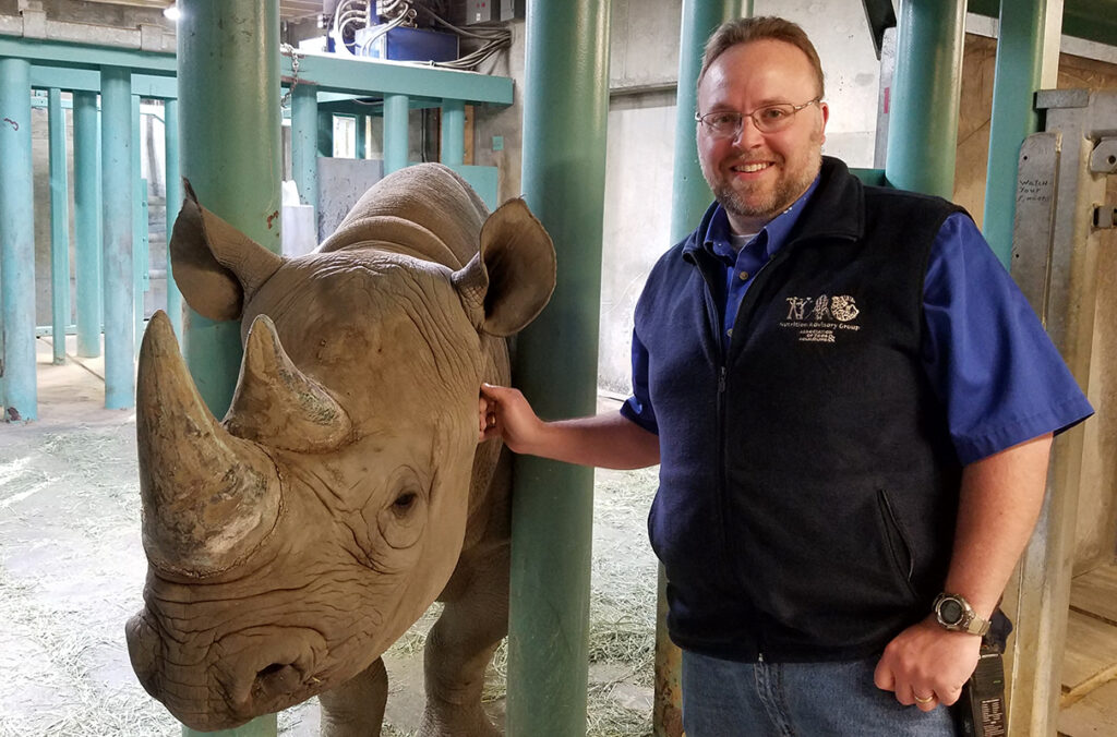 Matt Brooks standing next to a black rhino.