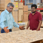Two researchers look at sheets of bamboo material.