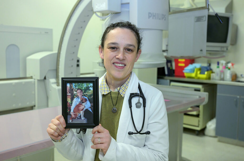 Jillian Haines of the Veterinary Teaching Hospital in Washington State University's College of Veterinary Medicine poses for a photo as she holds a picture of her with her dog Cake.
