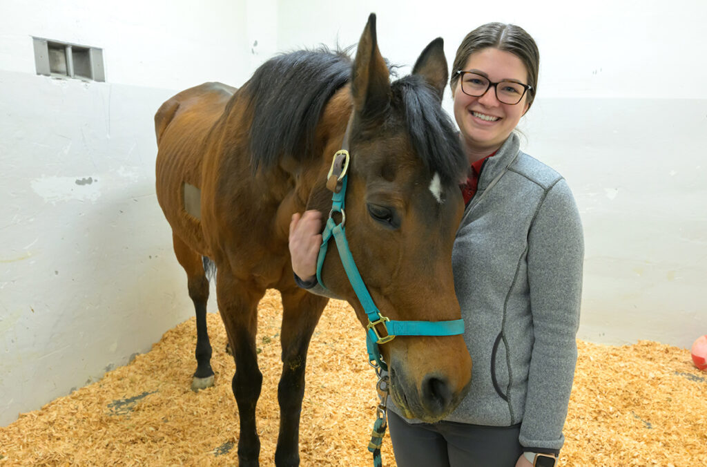 WSU veterinarian Erin Pinnell poses for a photo with Shirley, an American Quarter Horse.