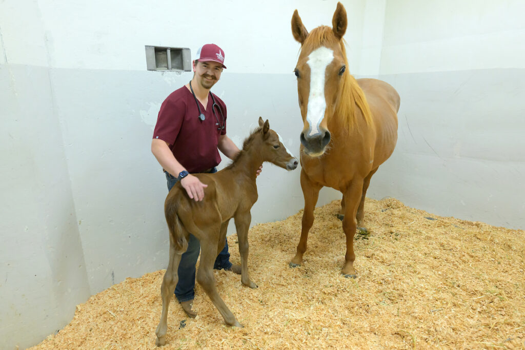 Taythen Larson poses with a mare and foal.