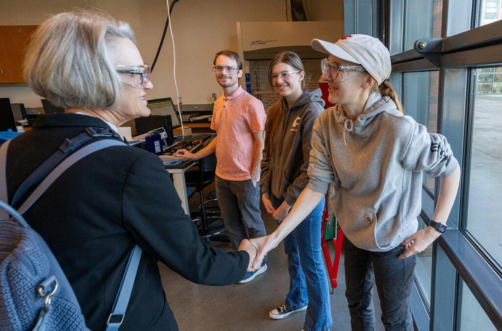 WSU President Elizabeth Cantwell shaking hands with a student.