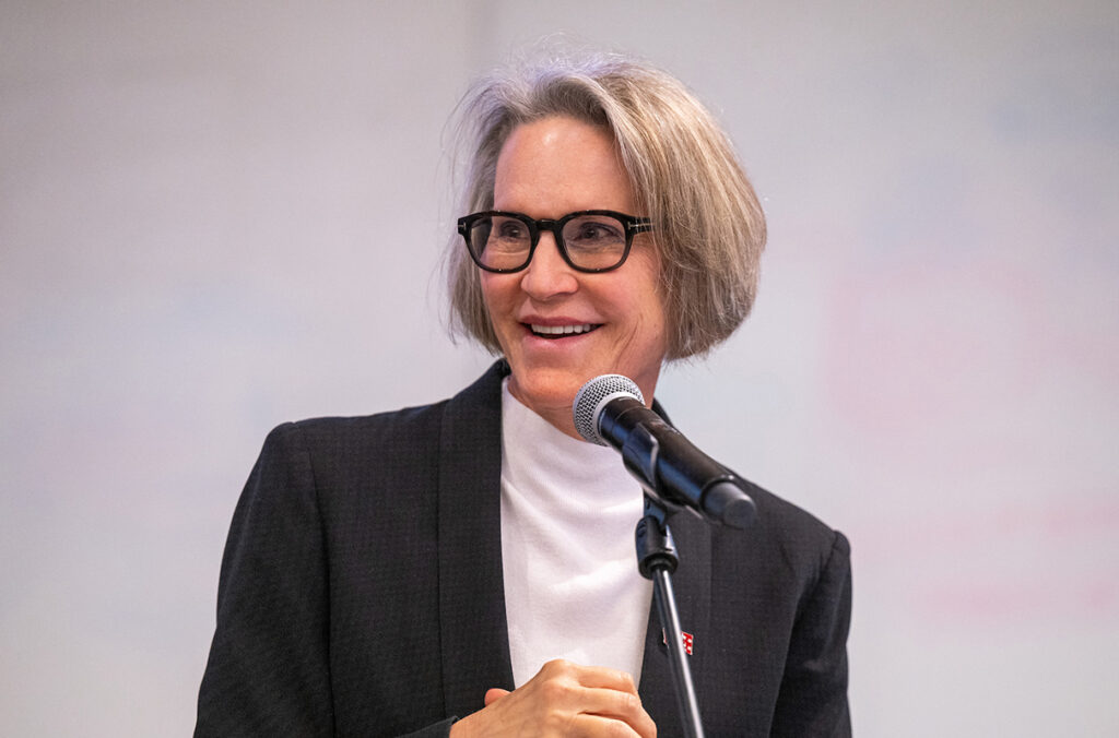 WSU President Elizabeth Cantwell smiling behind a microphone.