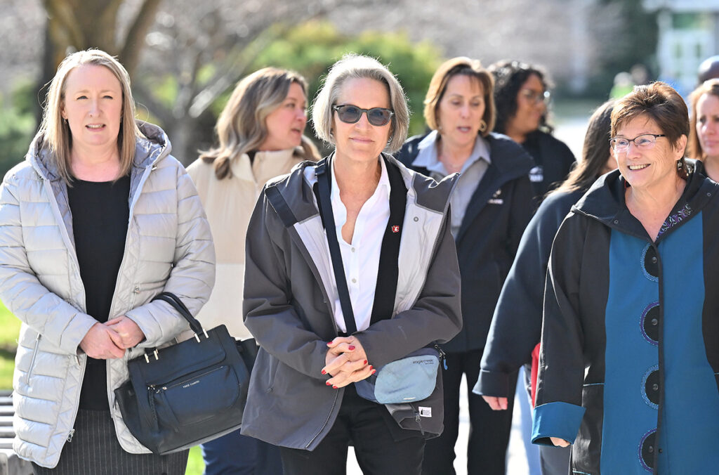 WSU President Elizabeth Cantwell and others walk across the WSU Spokane campus.