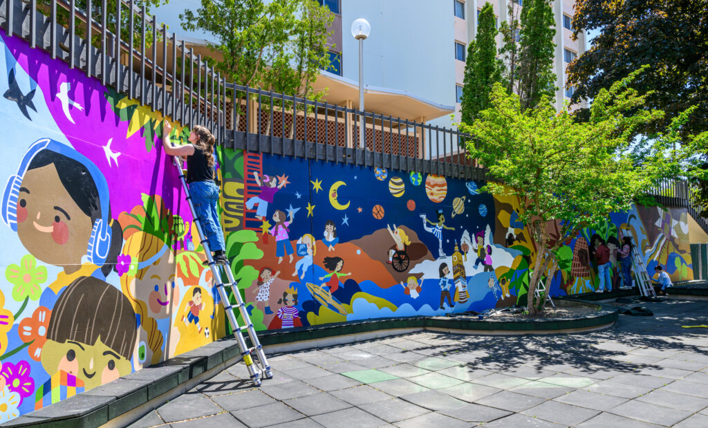 WSU students paint a mural at the WSU Children's Center. 