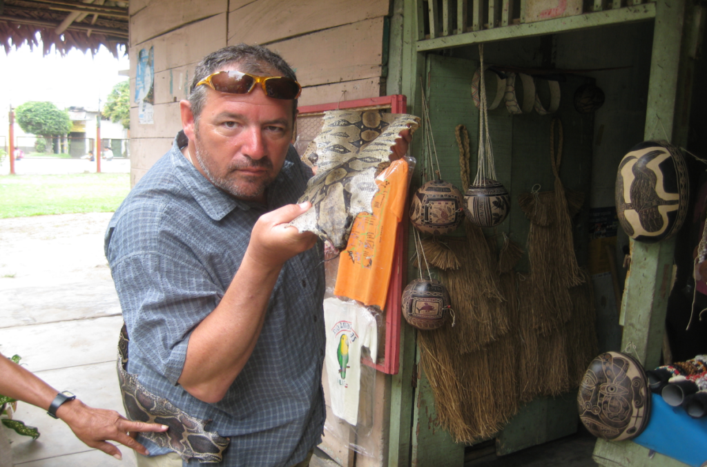 Buddy Levy poses with the skin of an anaconda in Peru.