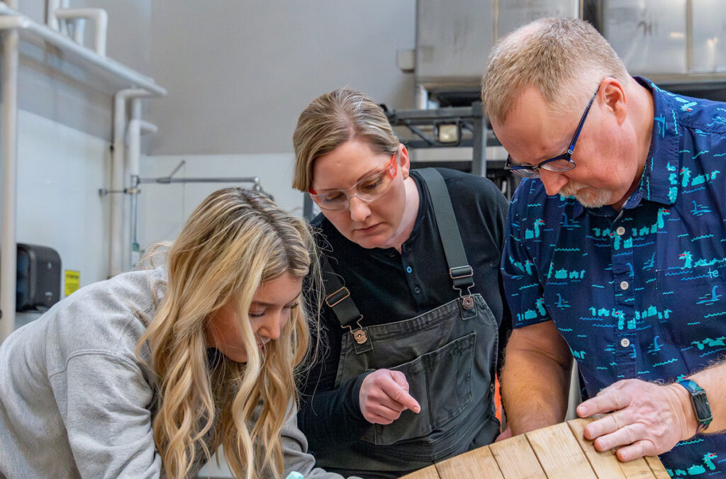 V&E students and faculty look at a wine cask.