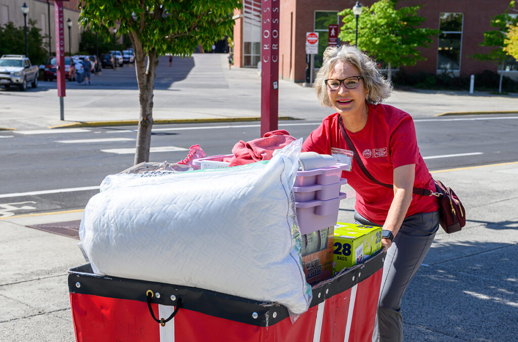 Elizabeth Cantwell pushing a cart full of items destined for a student's dorm room.