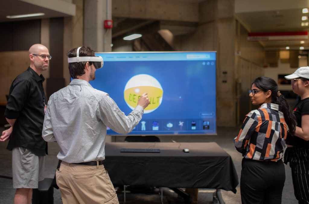 An XR programmer wearing a VR headset and demonstrating The NEXT's Visualization Space.