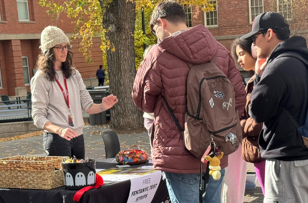 A CHS employee speaking to WSU students about free fentanyl test strips at a tabling event.