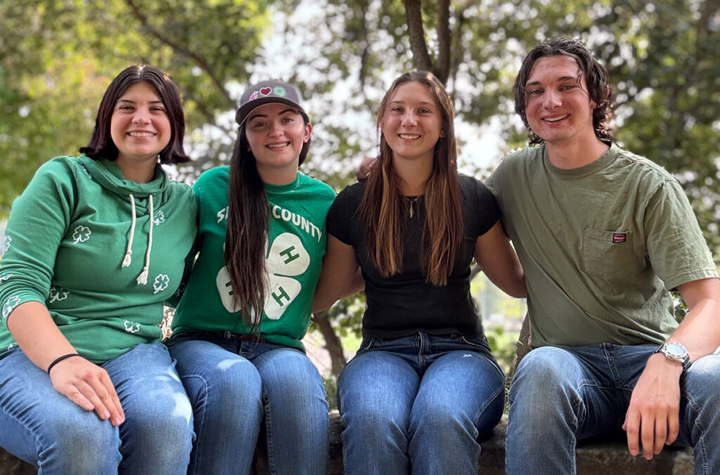 WSU 4-H Club leadership cabinet members seated with arms around one another.