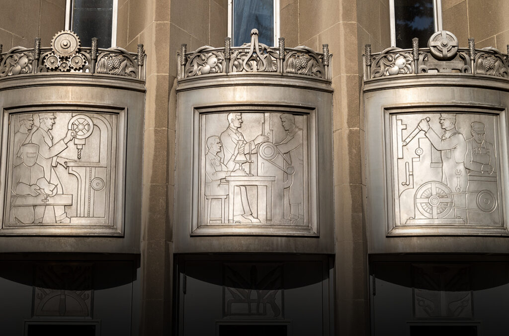 Artwork above exterior doors of Dana Hall depicting engineering students learning their craft.