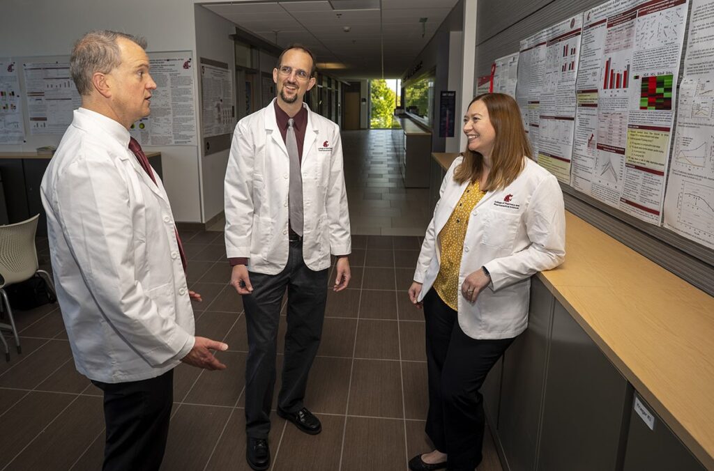 Three pharmacy professors discuss their research project.