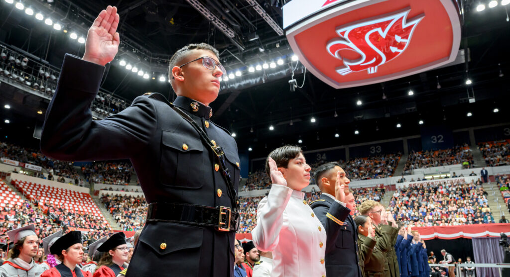 A line of ROTC members raising their right hands during a commissioning ceremony on the WSU Pullman campus.