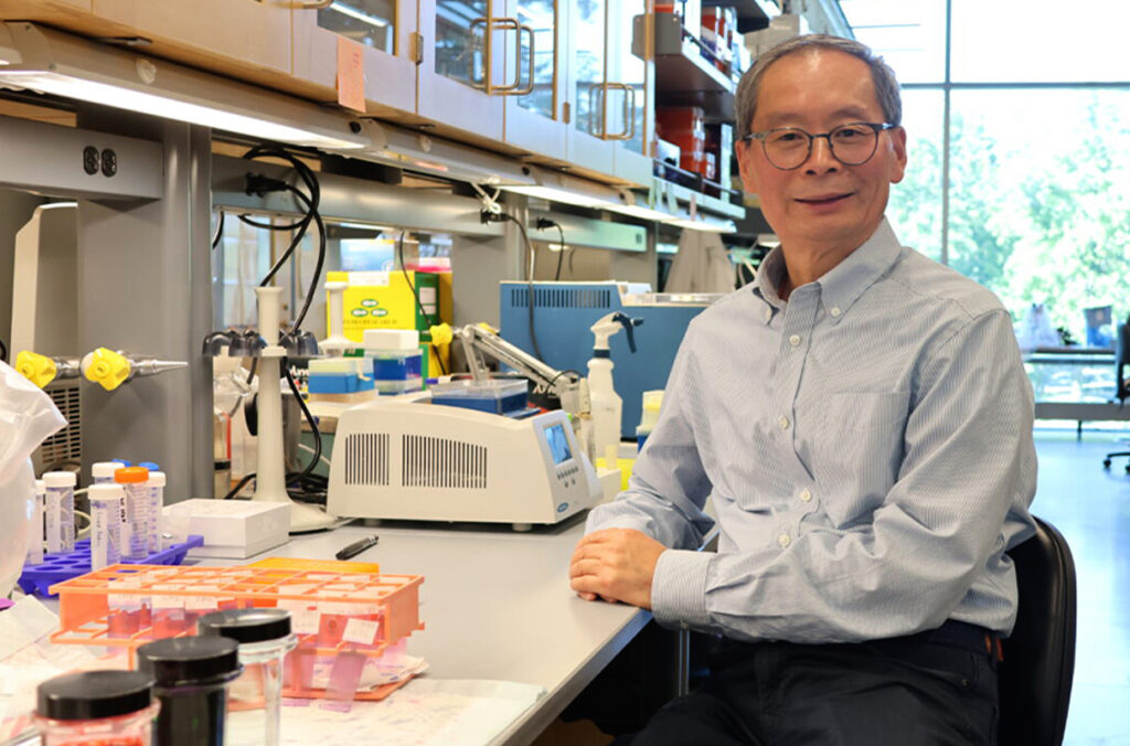 Closeup of Zhihua Jiang sitting in a lab.