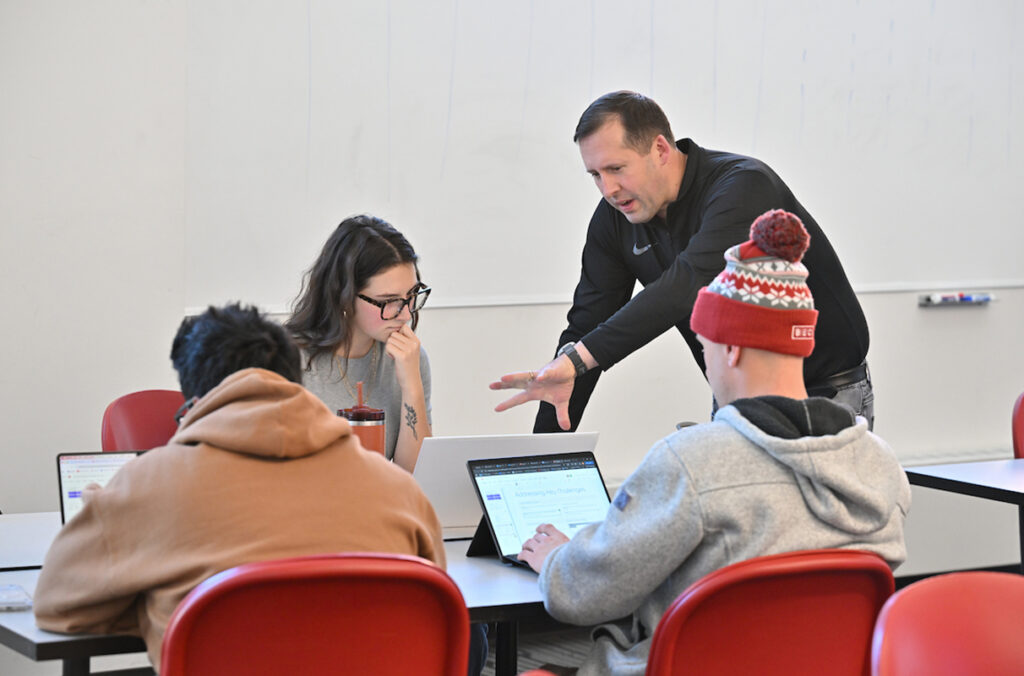 Professor Robert Crossler can be seen working with WSU student Eden Brooks and her teammates during the AI @ Carson Workshop.