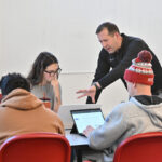 Professor Robert Crossler can be seen working with WSU student Eden Brooks and her teammates during the AI @ Carson Workshop.
