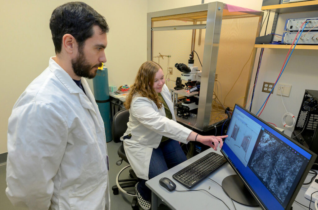 Two researchers viewing a computer screen in a lab.