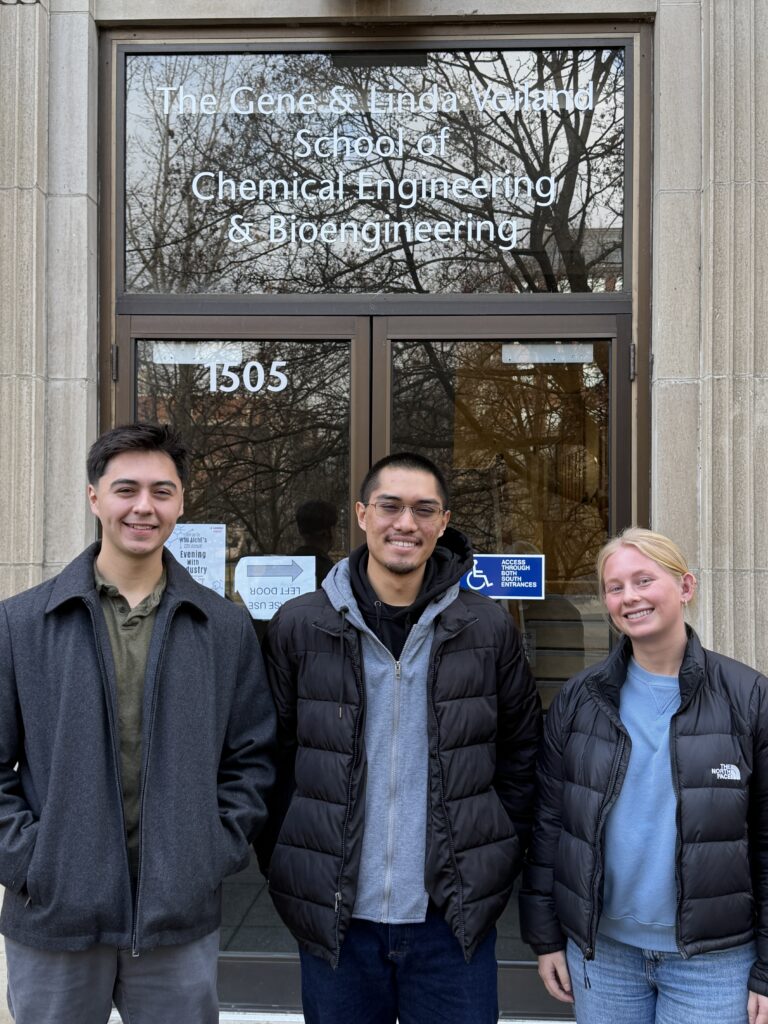 Miles Wilson, Josh Van Tuyl, and Marissa Andrews in front an entrance to the Voiland School of Chemical Engineering and Bioengineering. 