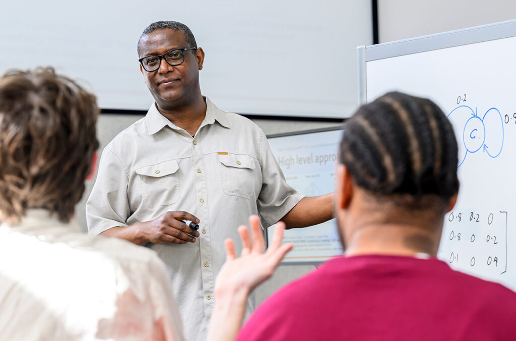 WSU associate professor Assefaw Gebremedhin addresses students before a whiteboard.
