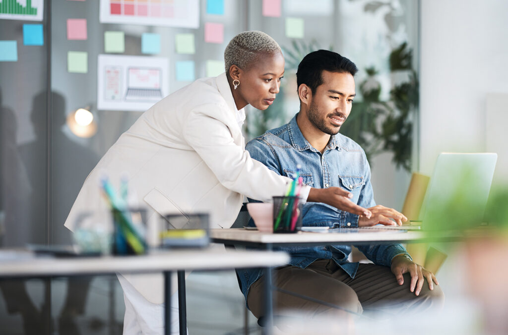 Two people can be seen working collaboratives at a table.