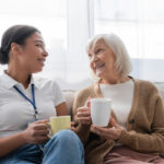 Closeup of two women, one older and one younger, talking over coffee.
