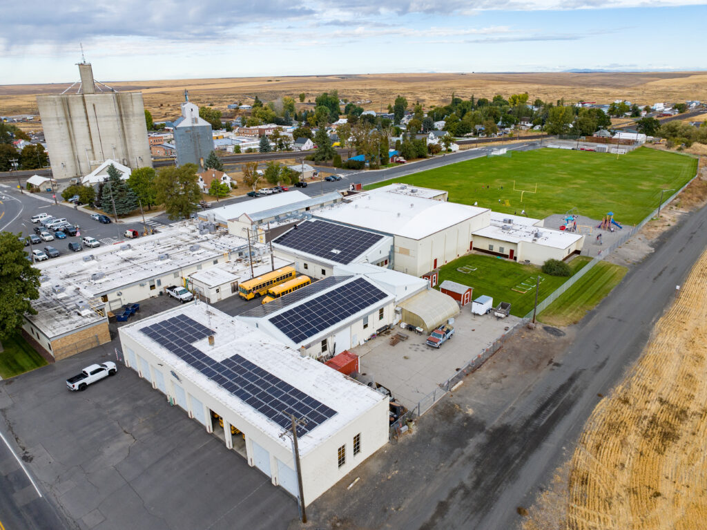 Overhead view of a rural school with solar panels installed on the roof.