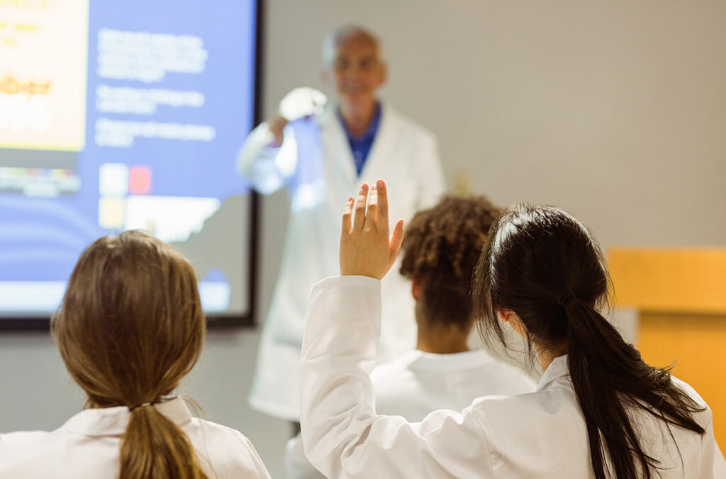 A medical professor calls on a student during a lecture.