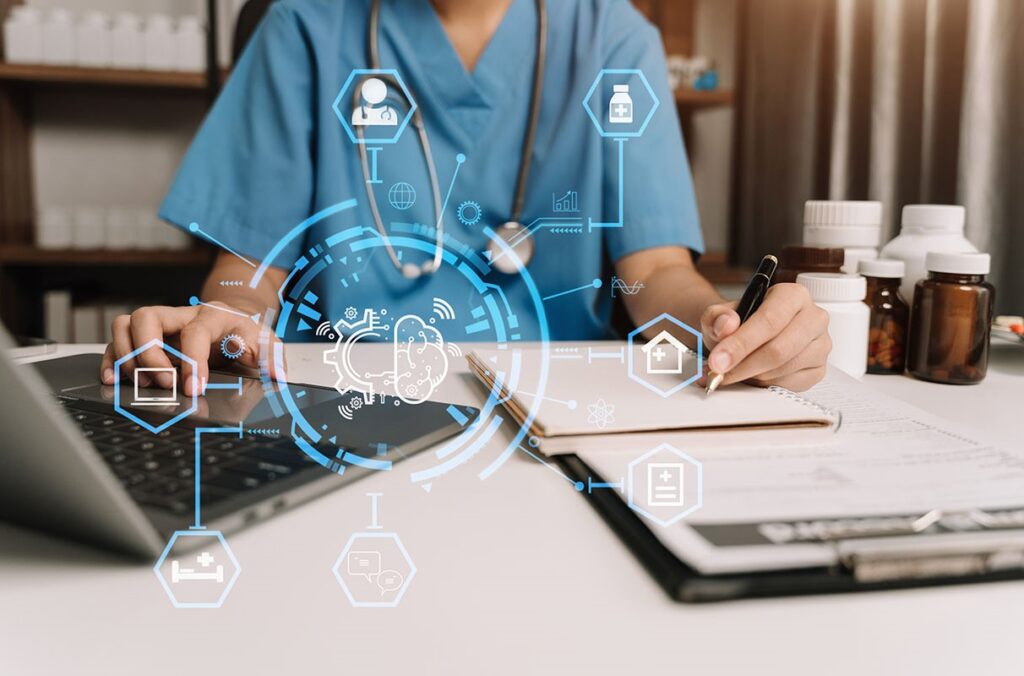 A clinician looks at a computer while making notes on a chart.
