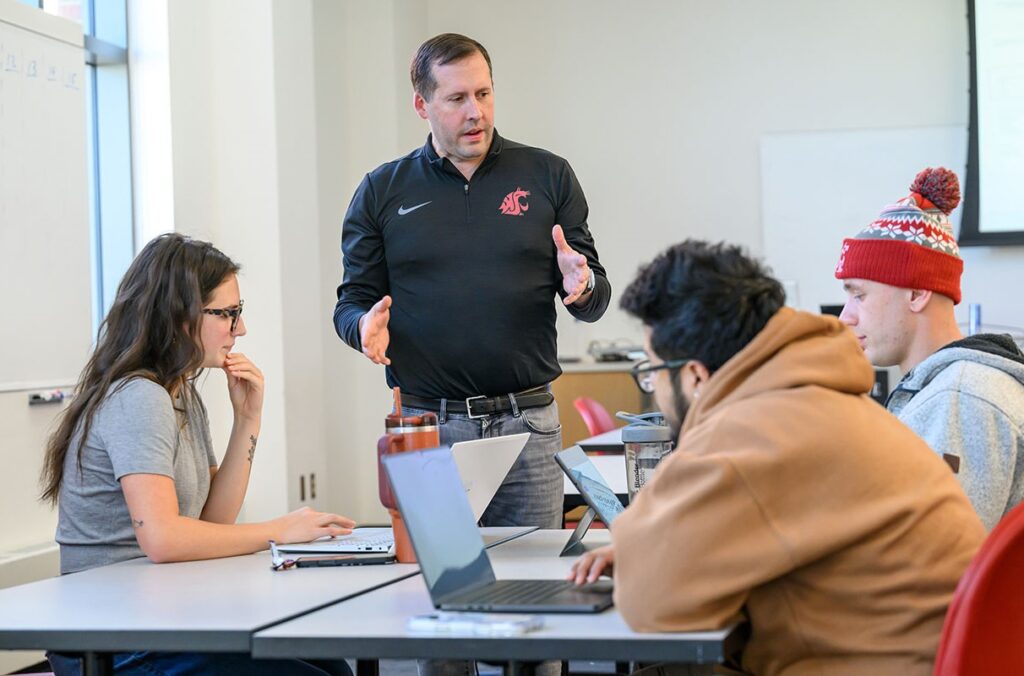 A professor talks to students during a class.