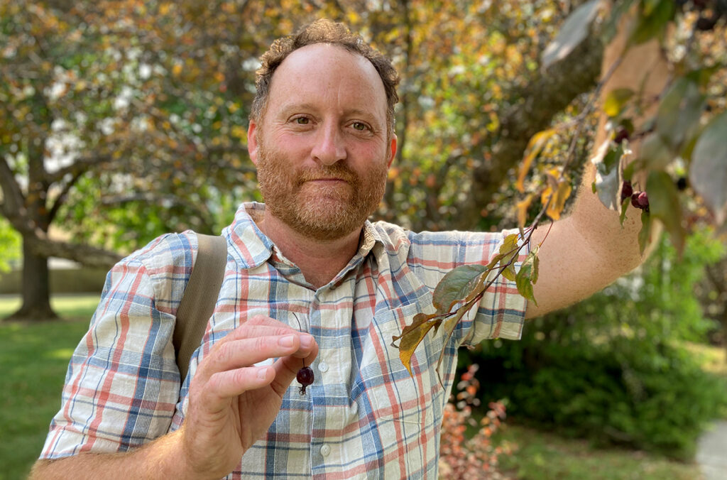 Jeff Wall holding the fruit from a crabapple tree.