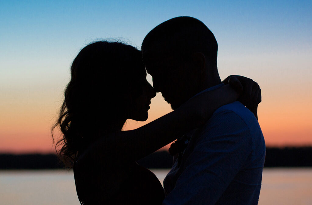Silhouette of a couple in a romantic embrace at sunset.