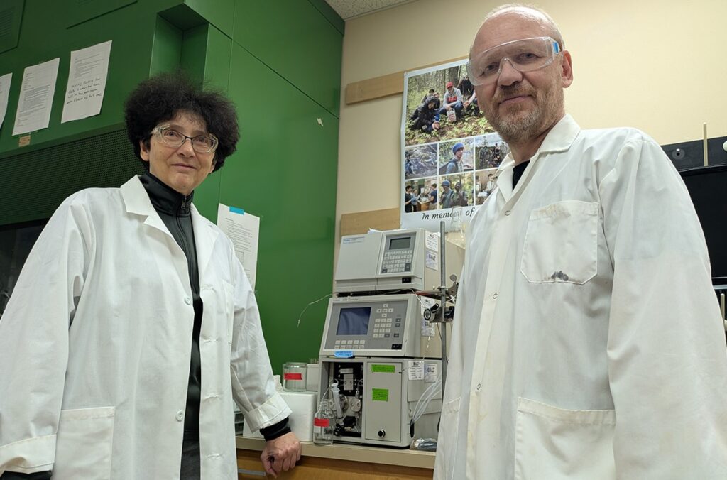 WSU researchers Alla Kostyukova and Dmitri Tolkachev standing next to a piece of equipment in a lab.