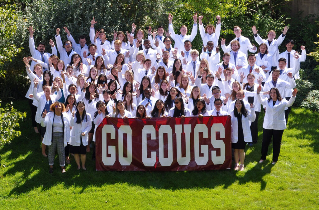 The WSU College of Pharmacy and Pharmaceutical Sciences Spokane Class of 2025 and a large Go Cougs sign.
