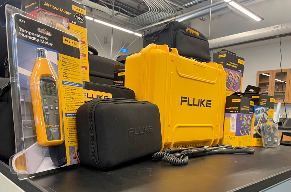 A collection of various Fluke engineering tools and cases gathered on a workspace.