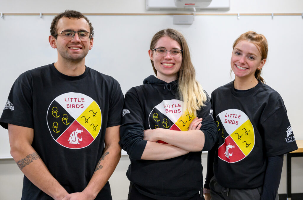 Three WSU students posing together in a classroom used for Little Birds games and activities.