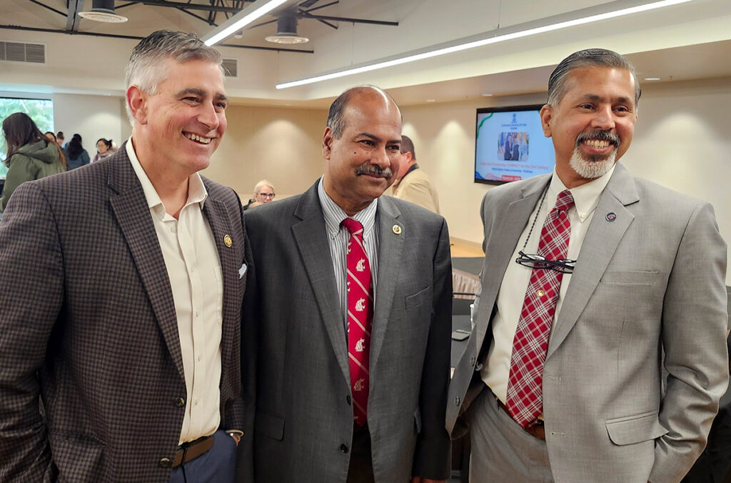 Michael Baumgartner, Partha Pande, and Raj Khosla standing and smiling.