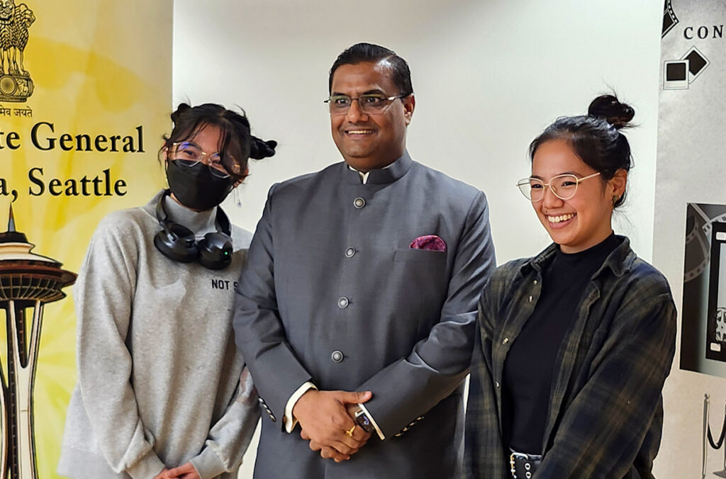 Prakash Gupta posing for a photo with two students.
