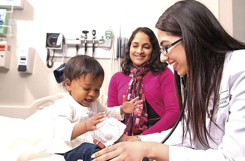 Image of Radha Nandagopal (middle), a pediatrician and WSU associate dean, helping train medical students.