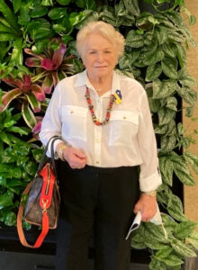 Barbara Stephanus in front of a plant wall.