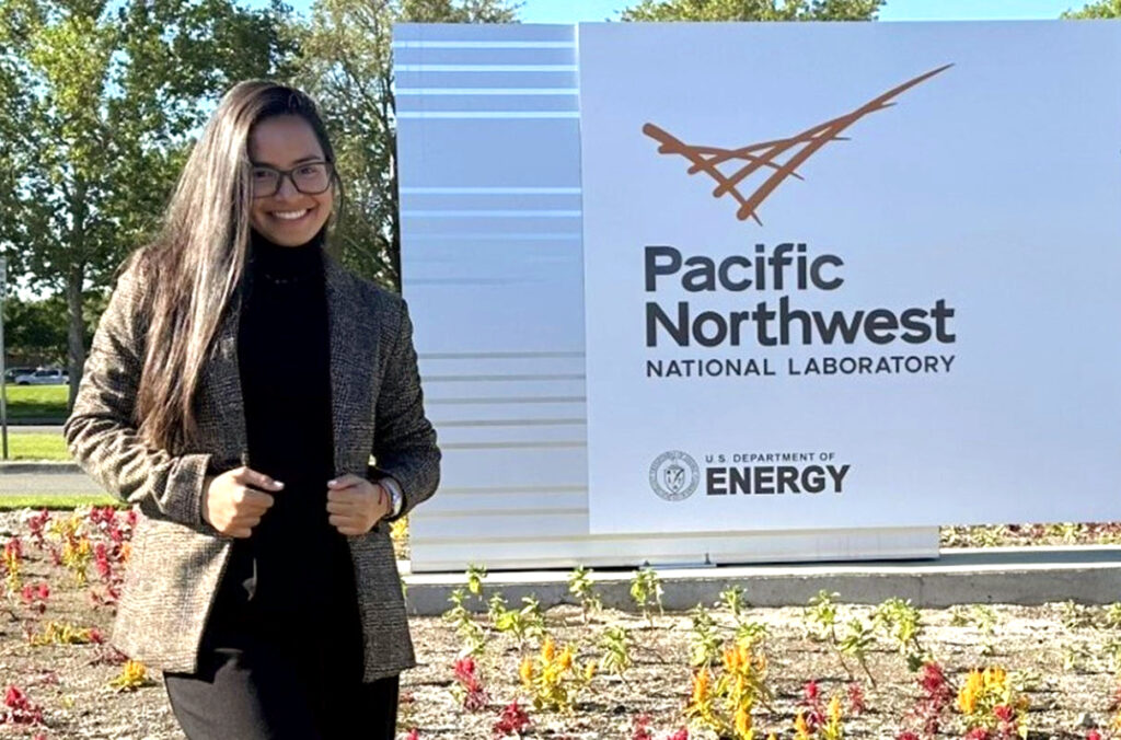 A PhD student stands outside the Pacific Northwest National Laboratory.