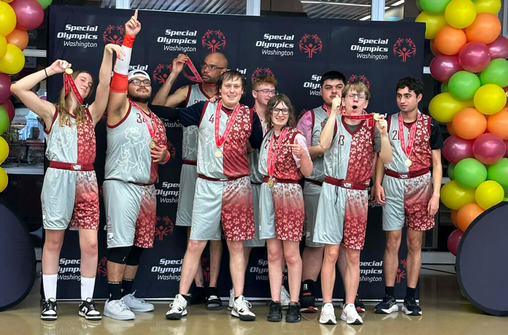 The Whitman County Superstars basketball team posing with gold medals.
