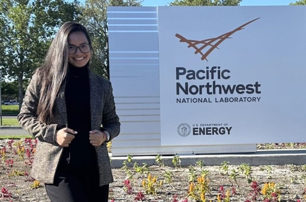 A PhD student stands outside the Pacific Northwest National Laboratory.