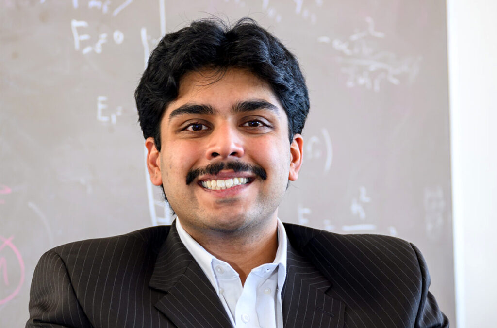 Closeup of Bhargav Iyer in front of a chalkboard.