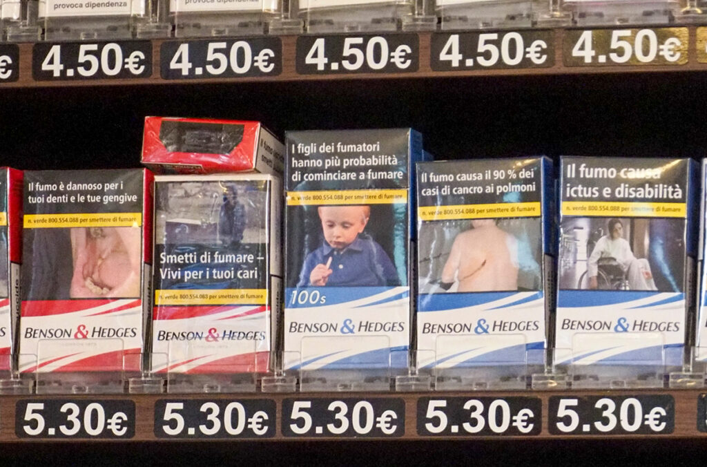Packages of cigarettes with graphic health warnings are shown on a shelf in Italy.