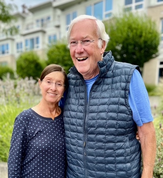 Mike and Kathy Hambelton pose for a photo outside in front of a building. 
