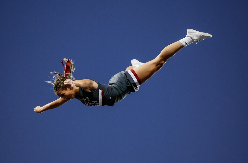 A person is tossed into the air, horizontal to the ground.